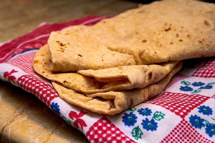 Soft homemade chapatis folded on a cloth